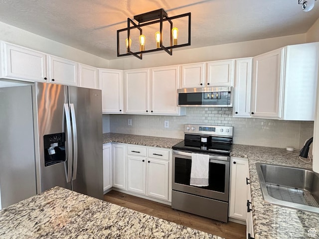 1165 N 2850 W, Provo, UT 84601 - kitchen with stainless steel appliances, dark wood-style floors, white cabinetry, and light stone counters