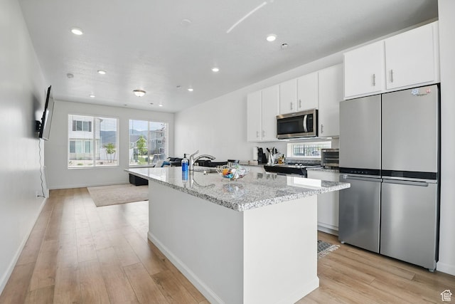 98 E Stroll Ave Unit 809, Saratoga Springs, UT 84045 - kitchen with stainless steel appliances, a center island with sink, light wood-style flooring, white cabinetry, and recessed lighting