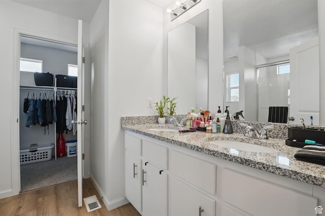 98 E Stroll Ave Unit 809, Saratoga Springs, UT 84045 - bathroom featuring a shower stall, wood finished floors, double vanity, and a walk in closet