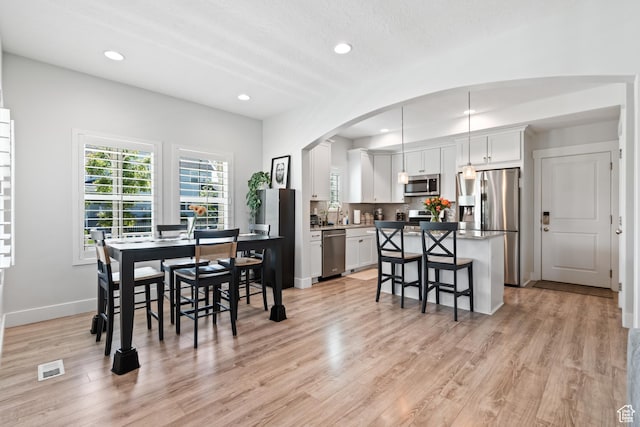 10401 S Liffey Ln, South Jordan, UT 84009 - dining area featuring light wood-type flooring, recessed lighting, and arched walkways