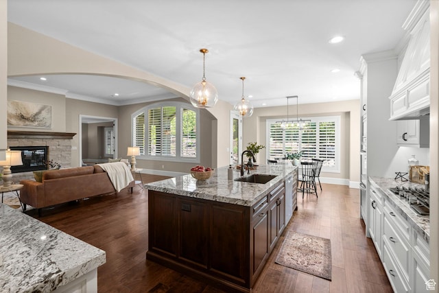 2209 E Viscaya Dr, Draper, UT 84020 - kitchen with arched walkways, dark brown cabinets, white cabinets, crown molding, and dark wood-style flooring