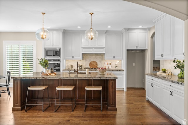 2209 E Viscaya Dr, Draper, UT 84020 - kitchen featuring stainless steel appliances, recessed lighting, arched walkways, dark wood-type flooring, and a breakfast bar