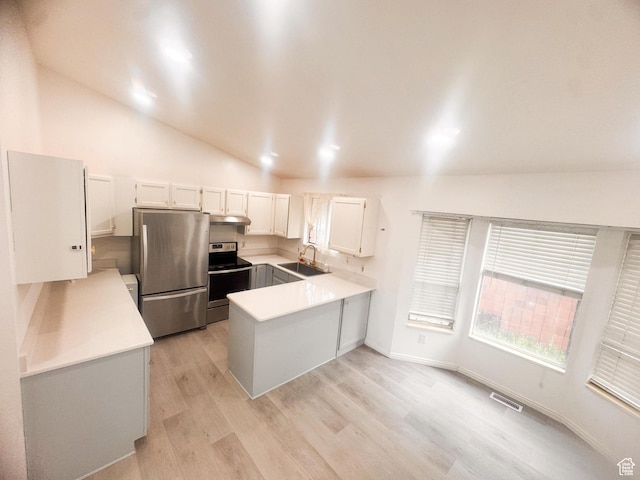 5351 S Royal Autumn Cir, Taylorsville, UT 84129 - kitchen featuring stainless steel appliances, a peninsula, vaulted ceiling, light countertops, and under cabinet range hood