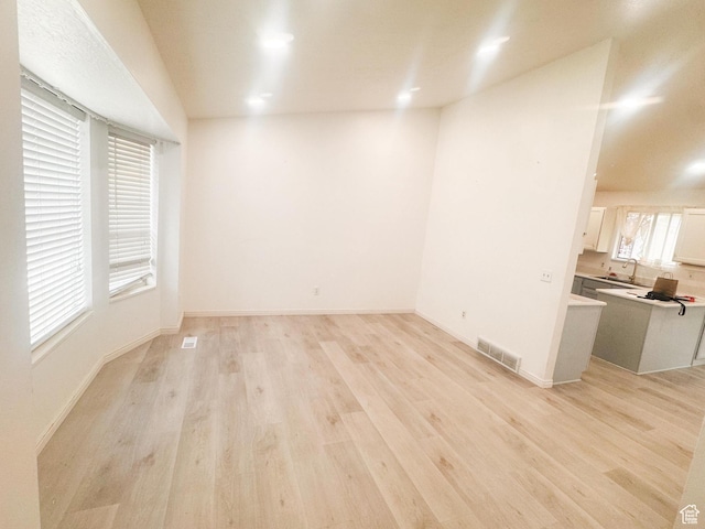 5351 S Royal Autumn Cir, Taylorsville, UT 84129 - unfurnished living room featuring a sink and light wood-style flooring