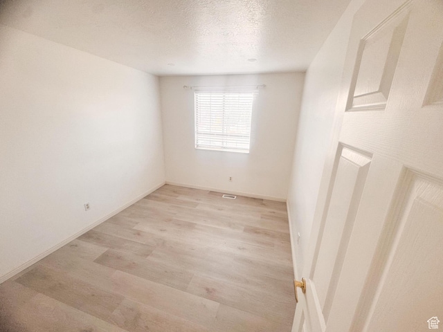 5351 S Royal Autumn Cir, Taylorsville, UT 84129 - spare room featuring light wood-style floors and a textured ceiling