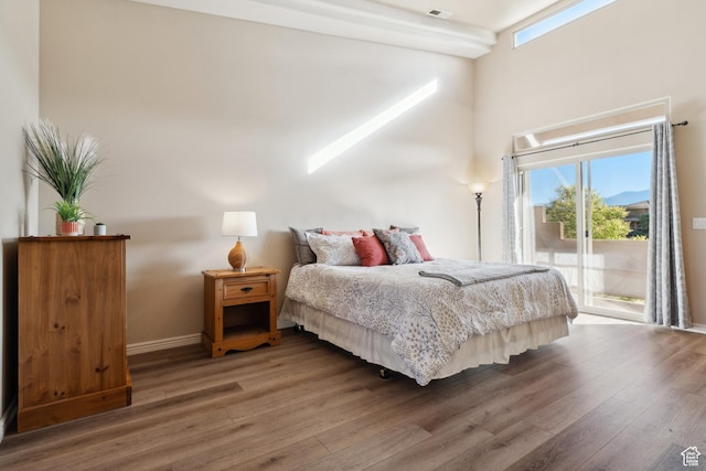 340 N Country Ln N Unit 27, St George, UT 84770 - bedroom featuring access to exterior, wood finished floors, multiple windows, and a high ceiling