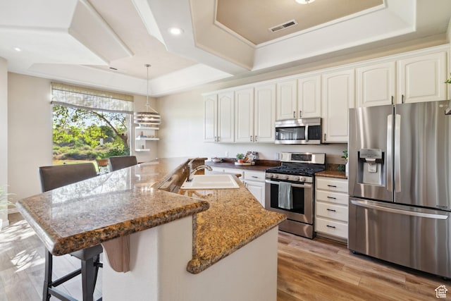 340 N Country Ln N Unit 27, St George, UT 84770 - kitchen featuring stainless steel appliances, a breakfast bar, white cabinetry, light wood-style flooring, and stone countertops