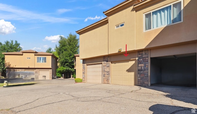 340 N Country Ln N Unit 27, St George, UT 84770 - view of home's exterior featuring stone siding, stucco siding, and an attached garage