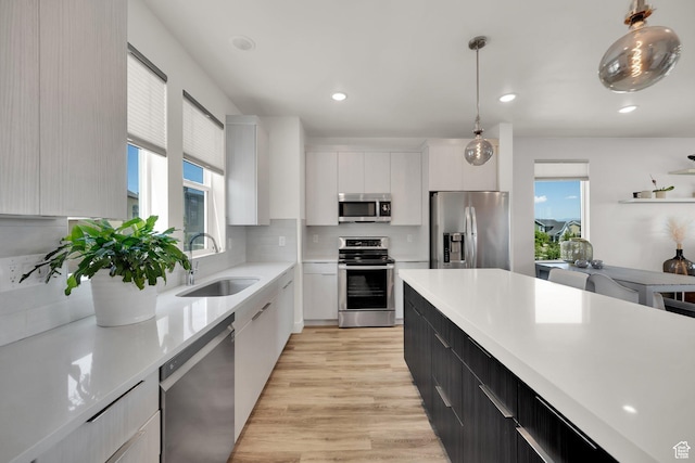 6366 W Sugarcane Dr S Unit 310, South Jordan, UT 84009 - kitchen with appliances with stainless steel finishes, white cabinetry, modern cabinets, hanging light fixtures, and light countertops