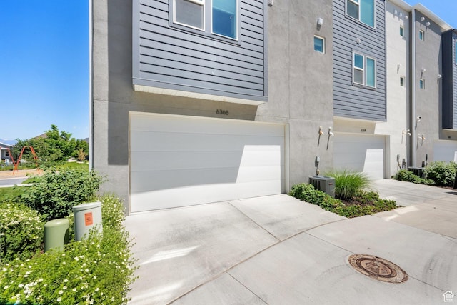 6366 W Sugarcane Dr S Unit 310, South Jordan, UT 84009 - view of side of home featuring an attached garage, concrete driveway, and stucco siding