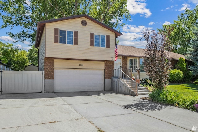 3285 W 6775 S, West Jordan, UT 84084 - split level home featuring brick siding, an attached garage, concrete driveway, and a shingled roof