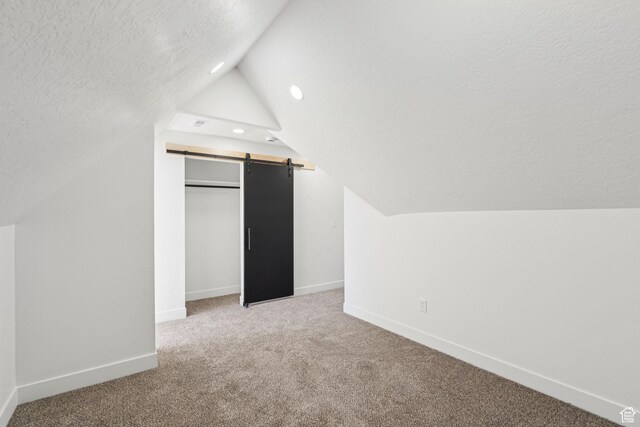 213 E 500 N, Nephi, UT 84648 - additional living space with a barn door, a textured ceiling, lofted ceiling, carpet, and recessed lighting
