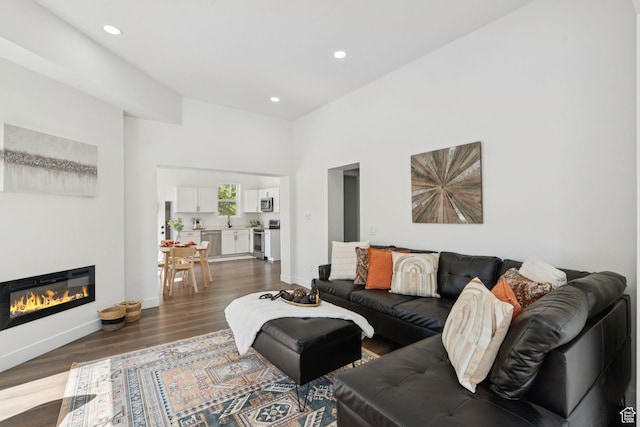 213 E 500 N, Nephi, UT 84648 - living room with dark wood-style flooring, recessed lighting, a glass covered fireplace, and a towering ceiling