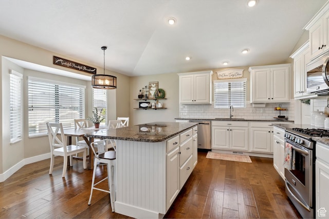 1412 S 4175 W, Syracuse, UT 84075 - kitchen with appliances with stainless steel finishes, a breakfast bar, healthy amount of natural light, white cabinets, and recessed lighting