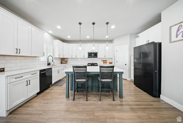 4888 W Transcendent Ct, West Jordan, UT 84081 - kitchen with black appliances, a kitchen island, light countertops, backsplash, and white cabinetry