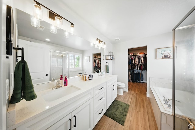 4888 W Transcendent Ct, West Jordan, UT 84081 - full bathroom with double vanity, a spacious closet, a shower stall, a garden tub, and wood finished floors
