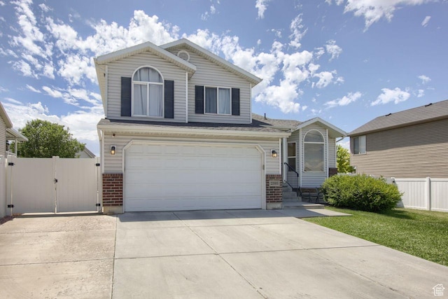 2595 W 4000 S, Roy, UT 84067 - traditional-style home with brick siding, a gate, concrete driveway, and a garage