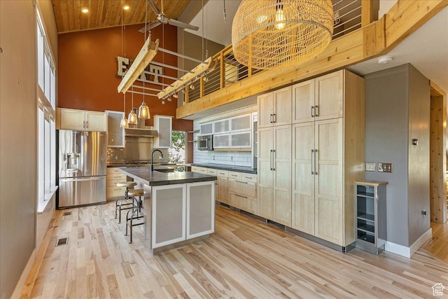 1794 E Longbranch Dr, Draper, UT 84020 - kitchen with stainless steel refrigerator with ice dispenser, high vaulted ceiling, dark countertops, light wood-style flooring, and decorative backsplash