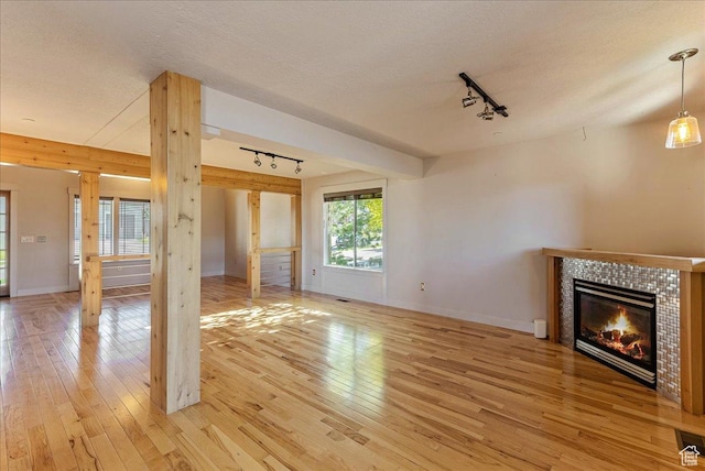 1794 E Longbranch Dr, Draper, UT 84020 - unfurnished living room featuring rail lighting, light wood finished floors, a fireplace, and a textured ceiling