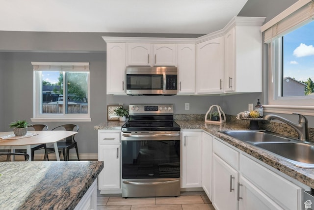 7839 N Apache Ln E, Eagle Mountain, UT 84005 - kitchen with appliances with stainless steel finishes, plenty of natural light, white cabinets, and light tile patterned flooring