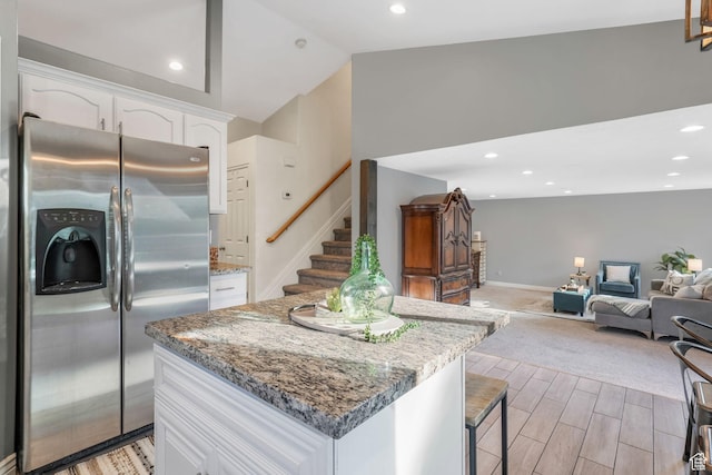 7839 N Apache Ln E, Eagle Mountain, UT 84005 - kitchen with stainless steel fridge, white cabinets, a kitchen island, light stone counters, and vaulted ceiling