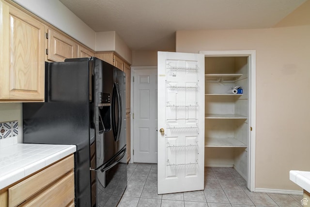 301 S 1200 E Unit 64, St George, UT 84790 - kitchen with light brown cabinets, tile counters, black fridge with ice dispenser, and light tile patterned floors