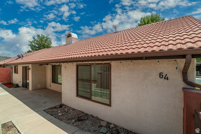 301 S 1200 E Unit 64, St George, UT 84790 - back of property featuring stucco siding, a tile roof, a patio area, and a chimney