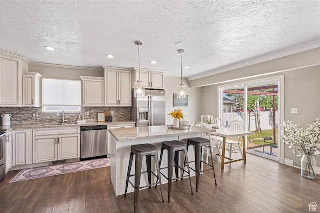 1673 W 9775 S, South Jordan, UT 84095 - kitchen with appliances with stainless steel finishes, a breakfast bar, dark wood-style floors, a kitchen island, and a textured ceiling