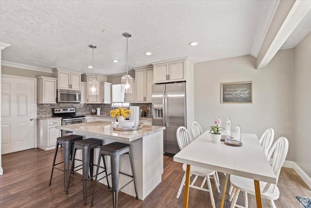 1673 W 9775 S, South Jordan, UT 84095 - kitchen featuring stainless steel appliances, a kitchen island, ornamental molding, a breakfast bar, and dark wood finished floors