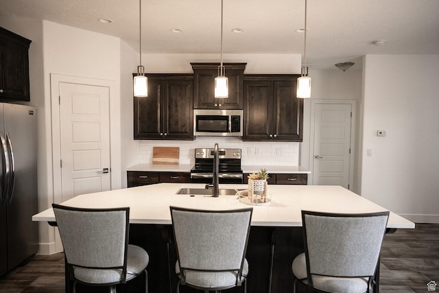 1060 N Ocotillo Dr, Washington, UT 84780 - kitchen with appliances with stainless steel finishes, backsplash, light countertops, a center island with sink, and recessed lighting