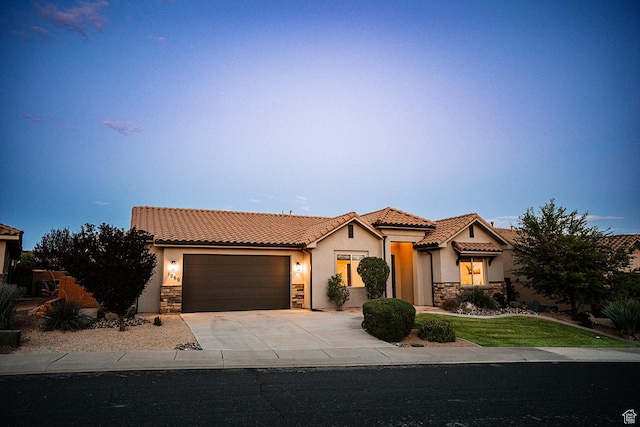 1060 N Ocotillo Dr, Washington, UT 84780 - mediterranean / spanish house with stone siding, stucco siding, a tile roof, an attached garage, and concrete driveway