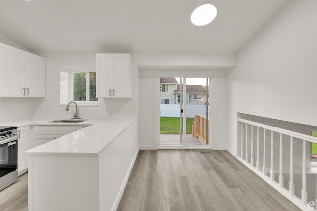 3042 W 8565 S, West Jordan, UT 84088 - kitchen with light countertops, white cabinets, light wood-style floors, stainless steel electric stove, and healthy amount of natural light
