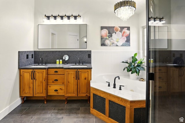 7414 S Regal Dr, West Jordan, UT 84081 - full bathroom featuring double vanity, a tub with jets, wainscoting, a chandelier, and decorative backsplash