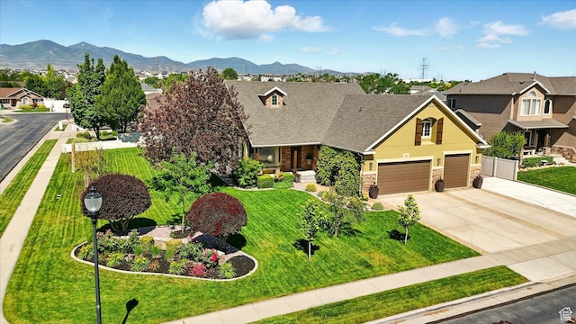 7414 S Regal Dr, West Jordan, UT 84081 - view of front facade featuring stone siding, driveway, a front lawn, and a mountain view