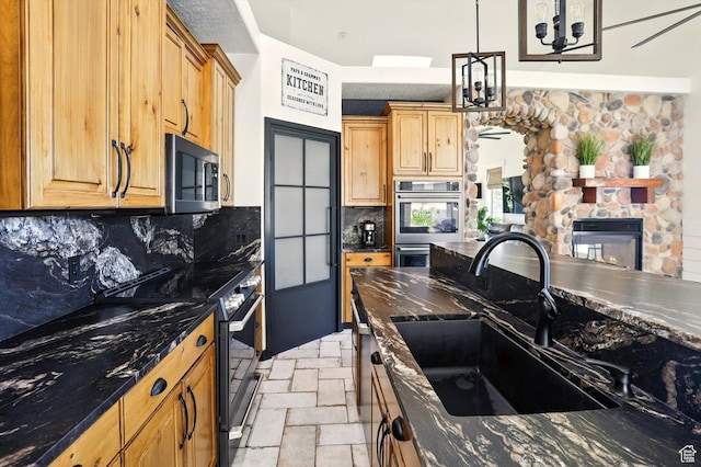 7414 S Regal Dr, West Jordan, UT 84081 - kitchen featuring appliances with stainless steel finishes, tasteful backsplash, a chandelier, pendant lighting, and stone tile flooring