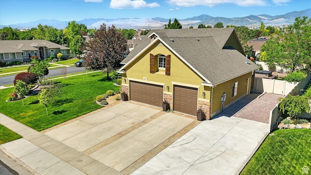 7414 S Regal Dr, West Jordan, UT 84081 - view of front of home with stucco siding, driveway, an attached garage, stone siding, and a mountain view