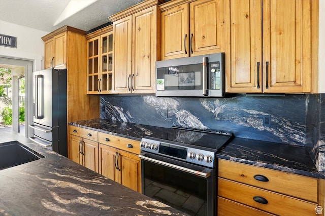 7414 S Regal Dr, West Jordan, UT 84081 - kitchen with stainless steel appliances, backsplash, glass insert cabinets, dark stone counters, and a textured ceiling
