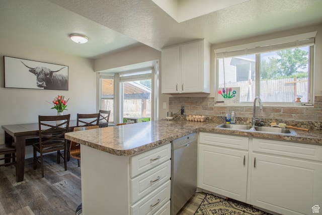 1211 E Spring Ridge Dr S, Sandy, UT 84094 - kitchen with stainless steel dishwasher, wood finished floors, a peninsula, backsplash, and white cabinetry