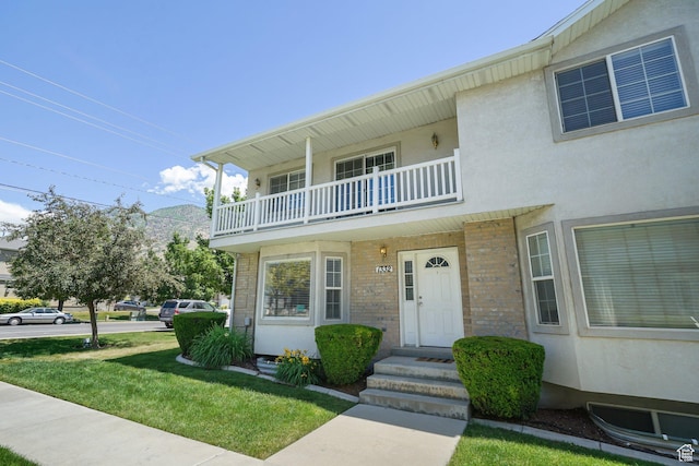 1332 S 1400 E, Provo, UT 84606 - townhome / multi-family property featuring a balcony, a front yard, stucco siding, and brick siding