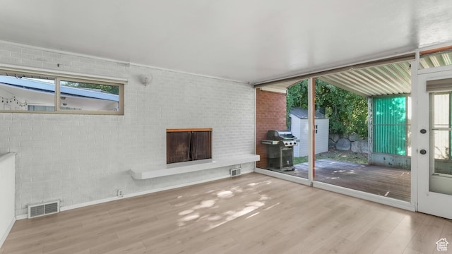 720 N 1200 E, Provo, UT 84606 - unfurnished living room featuring wood finished floors, a brick fireplace, and healthy amount of natural light