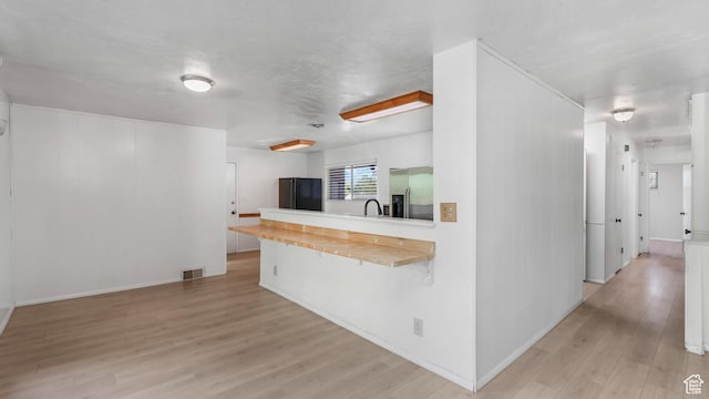 720 N 1200 E, Provo, UT 84606 - kitchen featuring stainless steel fridge, freestanding refrigerator, light wood-style flooring, light countertops, and a peninsula