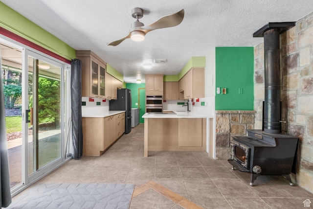 222 S 800 E, Alpine, UT 84004 - kitchen with stainless steel appliances, a wood stove, a ceiling fan, a textured ceiling, and light countertops