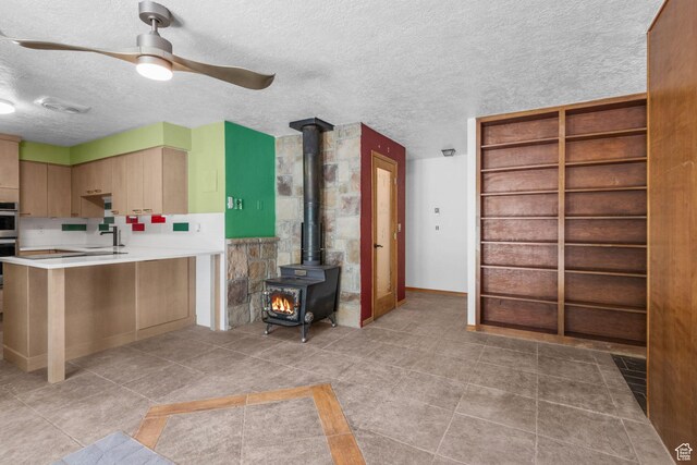 222 S 800 E, Alpine, UT 84004 - kitchen with a wood stove, a textured ceiling, ceiling fan, light countertops, and a peninsula