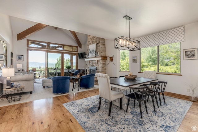 1085 W Links Dr, Midway, UT 84049 - dining room featuring a stone fireplace, plenty of natural light, beamed ceiling, a chandelier, and wood finished floors