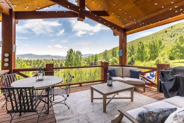 1085 W Links Dr, Midway, UT 84049 - deck with an outdoor living space, a mountain view, outdoor dining space, a grill, and a view of trees