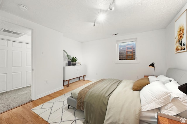 1114 W Briarcliff Ave S, Salt Lake City, UT 84116 - bedroom with light wood finished floors, track lighting, and a textured ceiling