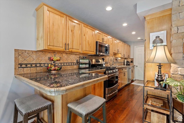 435 Aspen Dr Unit 8, Park City, UT 84098 - kitchen with stainless steel appliances, a kitchen bar, recessed lighting, dark wood-style flooring, and a peninsula