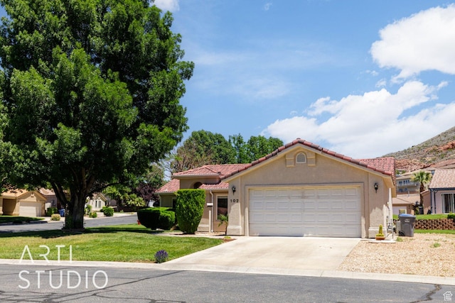 524 S Indian Hills Dr Unit 102, St George, UT 84770 - mediterranean / spanish-style house with driveway, a tile roof, a garage, stucco siding, and a front lawn