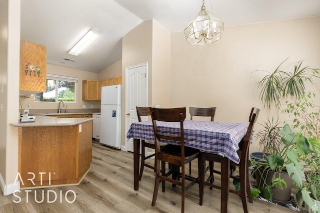 524 S Indian Hills Dr Unit 102, St George, UT 84770 - dining space featuring light wood-style flooring, vaulted ceiling, and a chandelier