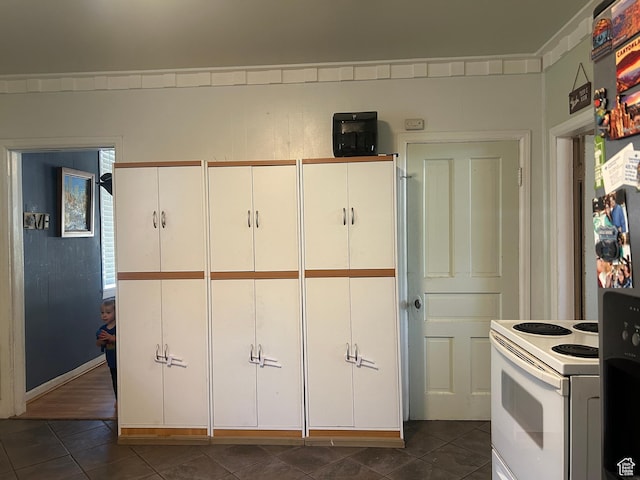228 S 2 W, Preston, ID 83263 - kitchen featuring white range with electric cooktop, dark tile patterned floors, and white cabinetry